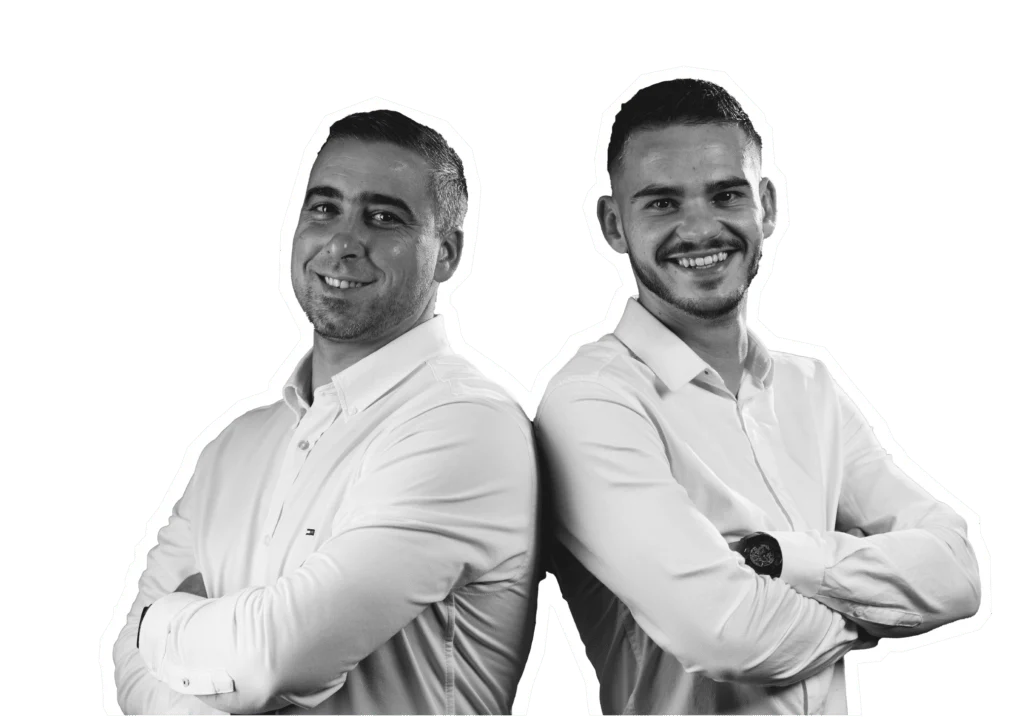 Image de deux hommes professionnels, souriants, habillés en chemises blanches, debout côte à côte. Ils se tiennent les bras croisés et affichent des expressions confiantes, sur un fond isolé blanc.