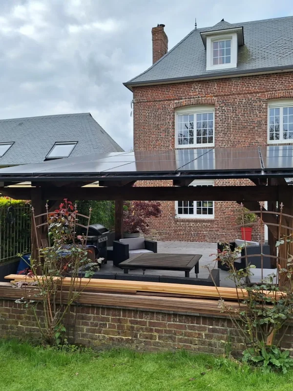 Une terrasse moderne avec un espace de vie extérieur couvert, équipée de panneaux solaires installés sur le toit.