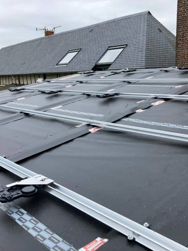 Vue rapprochée de supports de panneaux solaires installés sur un toit avec des maisons en arrière-plan